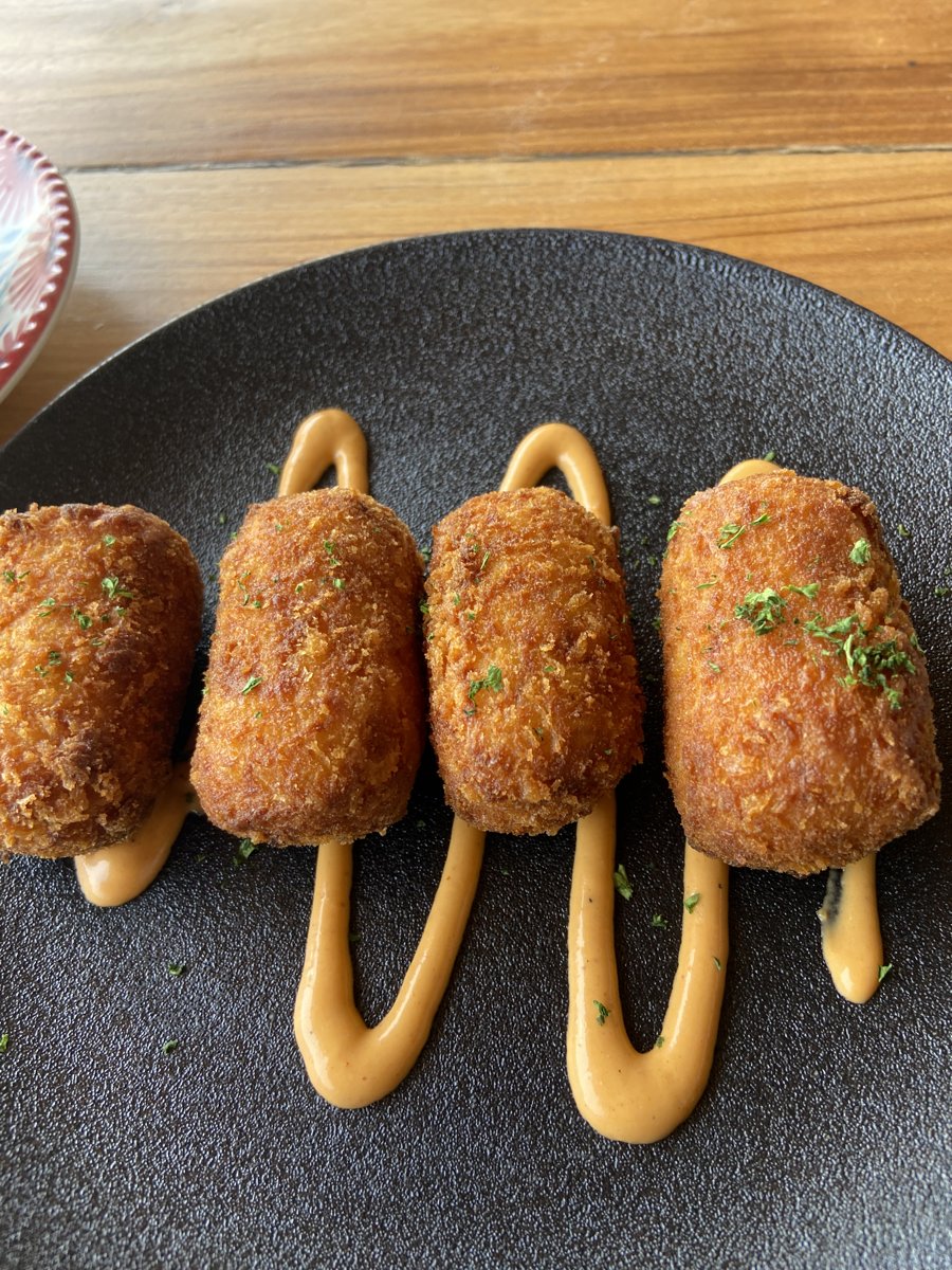 Golden croquettes plated with sauce at a restaurant in Colombia