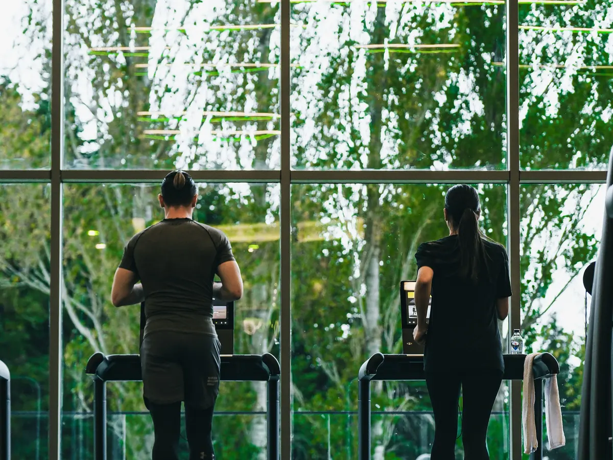People exercising on treadmills in a bright fitness center