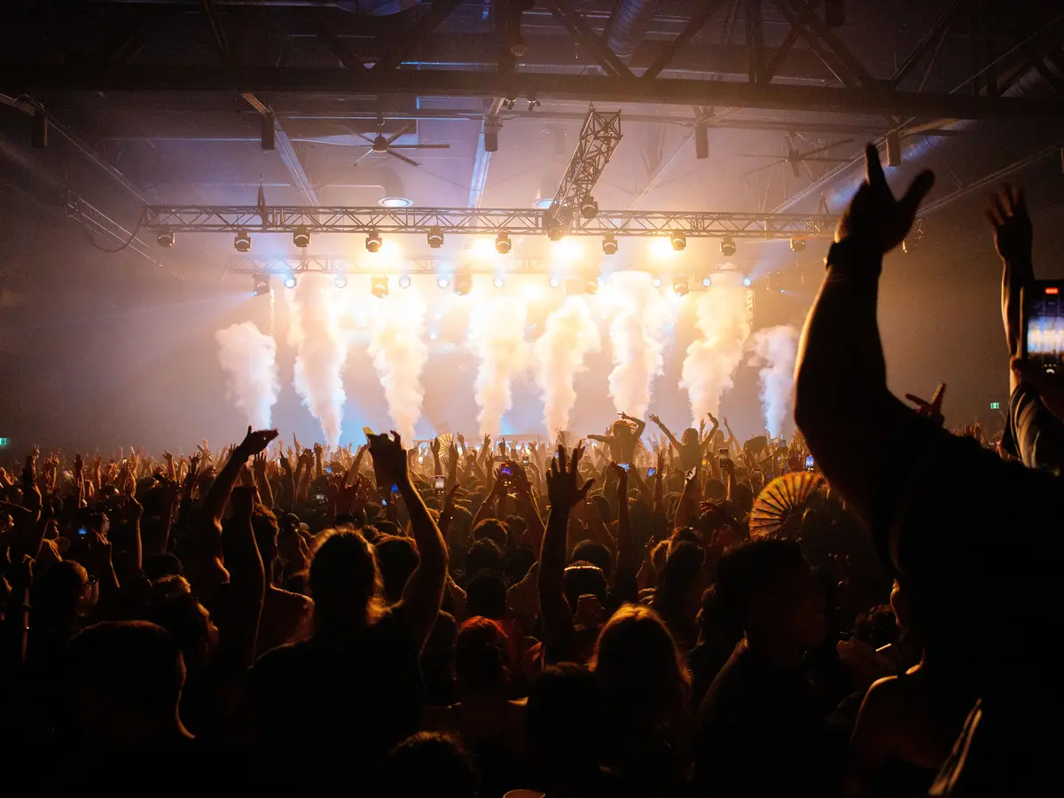 Crowd enjoying a live concert beneath stage lights