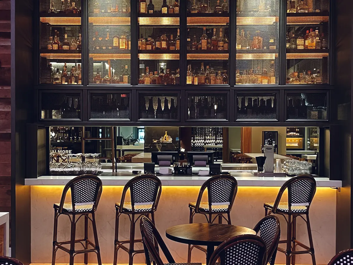 Restaurant bar with tables, seating, and a stocked back bar